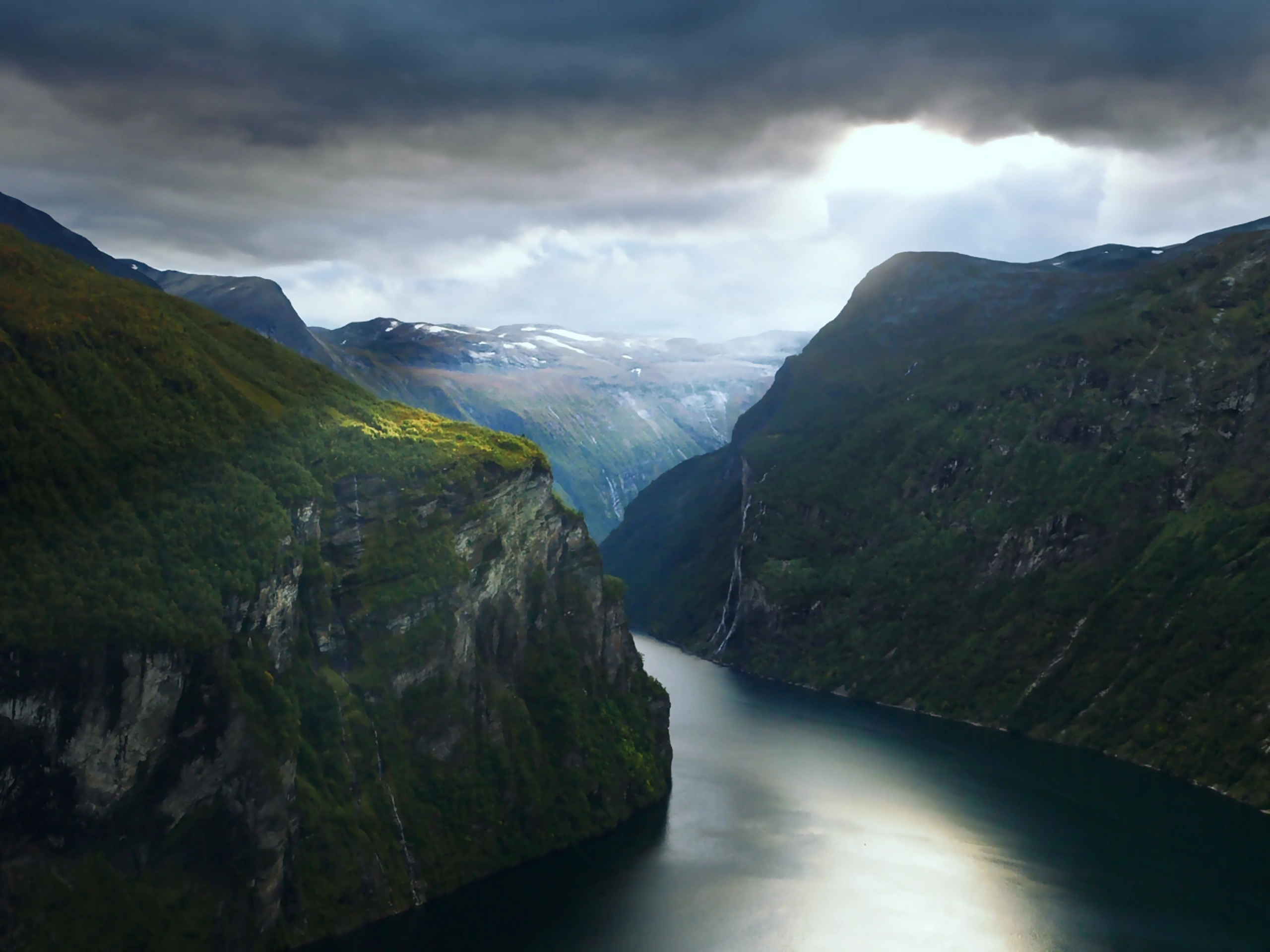 The West Norwegian Fjords under cloud — sheer walls and waterfalls dropping to the fjord